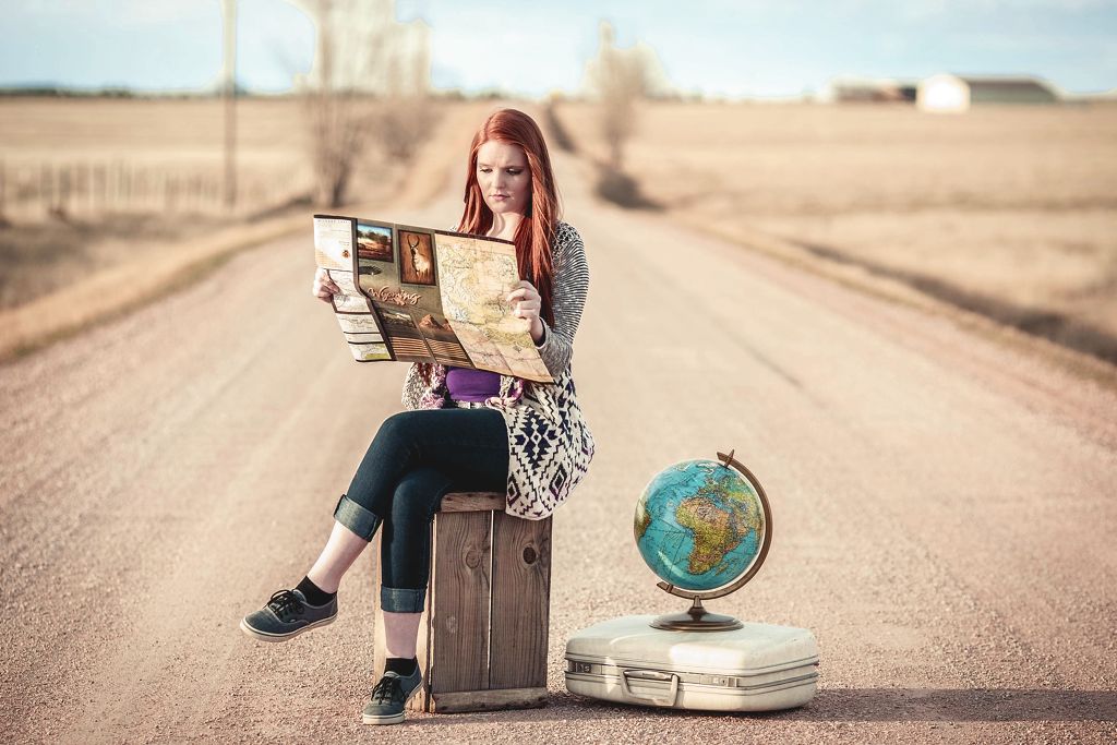 Eine junge Frau durchstöbert ein Reisemagazin