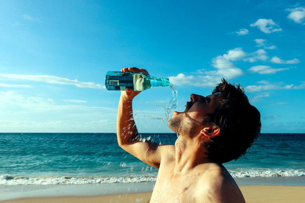 Ein durstiger Man trinkt Wasser aus einer Flasche