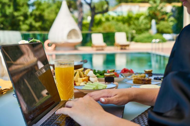 Eine Person bucht am Laptop eine Reise in einem Hotel